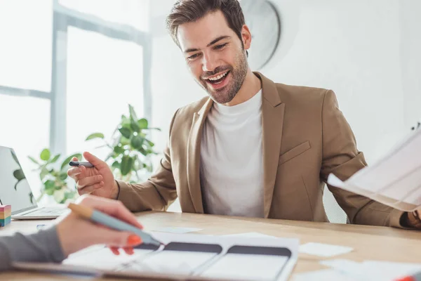 Enfoque selectivo del diseñador ux sonriente desarrollo de prototipo de aplicación móvil con colega en la oficina - foto de stock