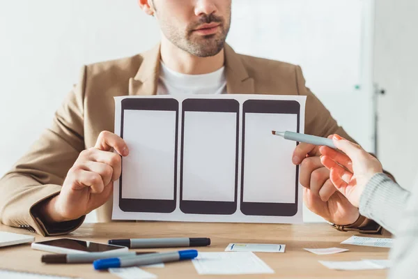 Cropped view of designers planning app on mobile website template at table — Stock Photo