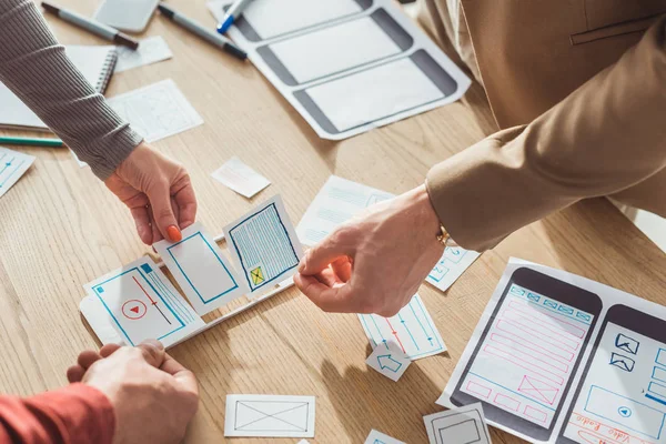 Cropped view of creative designers planning mobile app interface at table — Stock Photo