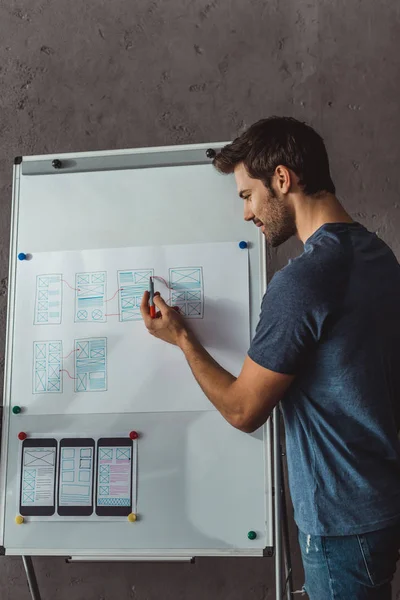 Seitenansicht des Designers, der User Experience Design auf Whiteboard im Büro entwickelt — Stockfoto