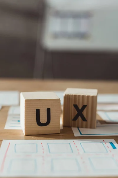 Selektiver Fokus der Würfel mit UX-Buchstaben und Layouts des User Experience Designs auf dem Tisch — Stockfoto