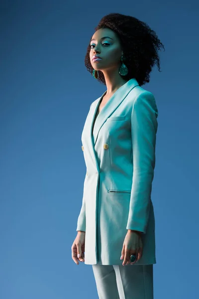 Attractive african american woman in suit isolated on blue — Stock Photo