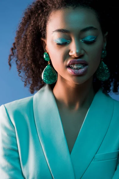 Femme afro-américaine élégante avec les yeux fermés et les bretelles isolées sur bleu — Photo de stock