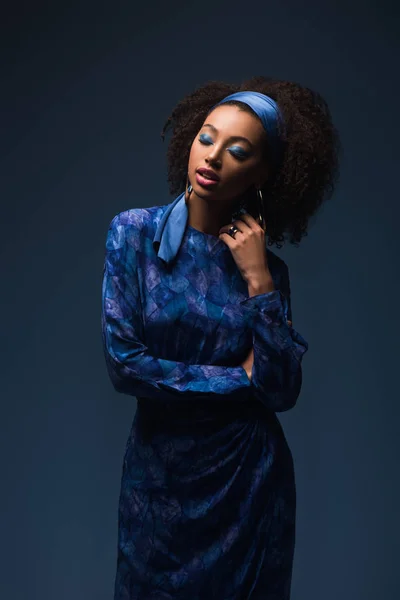Atractiva mujer afroamericana con los ojos cerrados aislados en azul - foto de stock