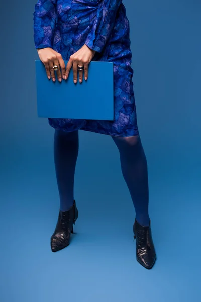 Vista cortada de mulher afro-americana segurando pasta isolada em azul — Fotografia de Stock