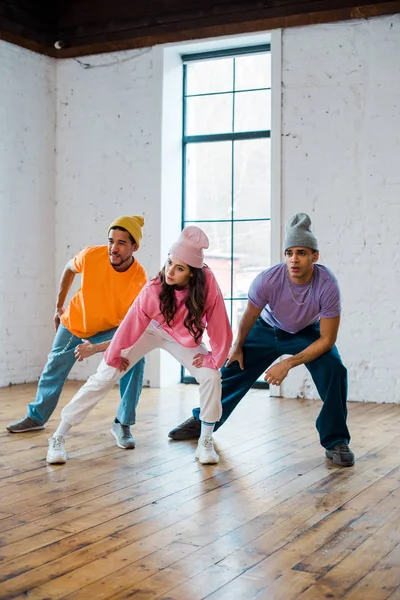 Bailarines multiculturales elegantes y jóvenes en sombreros breakdance - foto de stock