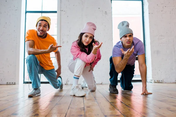 Stylish african american dancer in hat pointing with finger at attractive young woman — Stock Photo