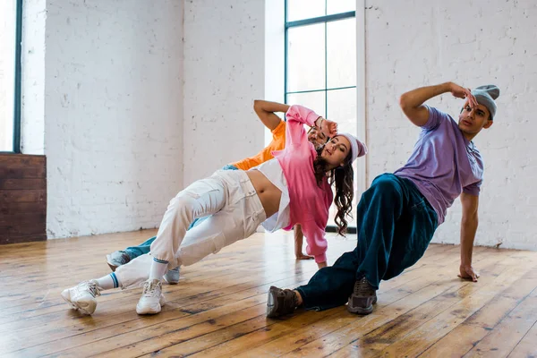 Alla moda uomini multiculturali breakdance con bella donna — Foto stock