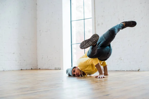 Jovem homem de chapéu breakdancing no estúdio de dança — Fotografia de Stock