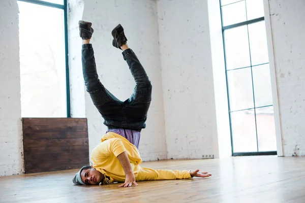 Homem de chapéu breakdancing no chão no estúdio de dança — Fotografia de Stock