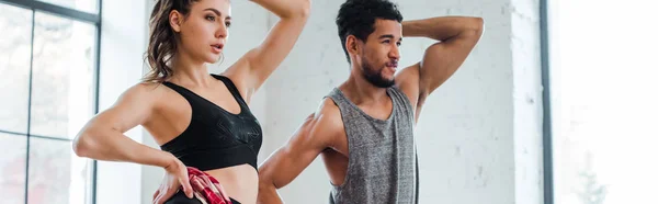 Panoramic shot of girl dancing jazz funk with handsome african american man — Stock Photo