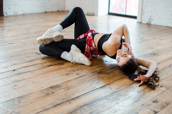 Attraktives Mädchen auf dem Boden liegend, während es Jazz-Funk tanzt — Stockfoto