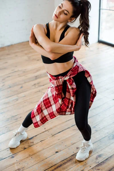 Jeune femme aux bras croisés en studio de danse — Photo de stock