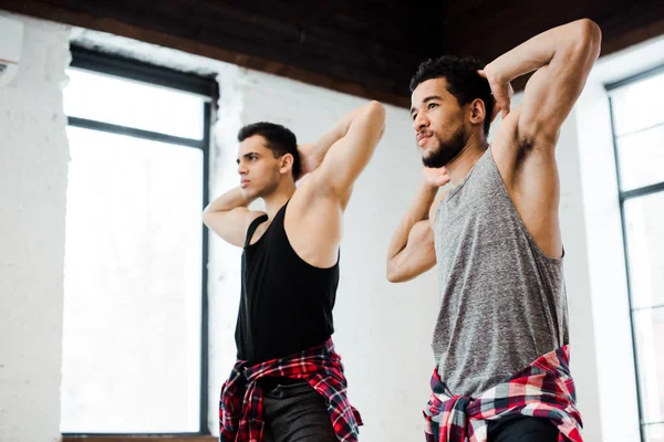 Muskulöse multikulturelle Tänzer posieren, während sie Jazz-Funk im Tanzstudio tanzen — Stockfoto