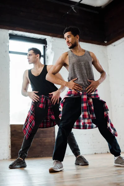 Handsome multicultural dancers posing while dancing jazz funk in dance studio — Stock Photo