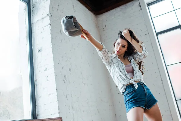 Bella ballerina tenendo tappo e toccando i capelli in studio di danza — Foto stock