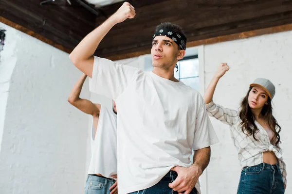 Selective focus of handsome man and multicultural dancers dancing hip-hop — Stock Photo