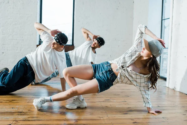 Danseurs multiculturels branchés breakdance dans le studio de danse — Photo de stock