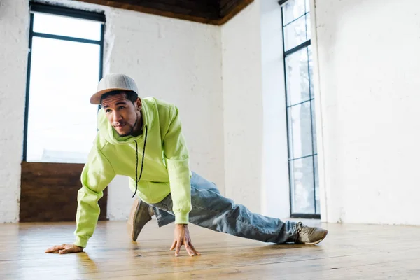 Bel homme afro-américain en casquette breakdance en studio de danse — Photo de stock