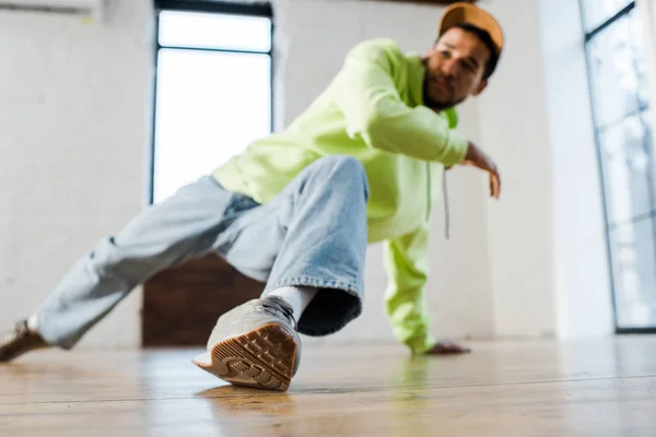 Foco seletivo do homem americano africano elegante em cap breakdancing no estúdio de dança — Fotografia de Stock
