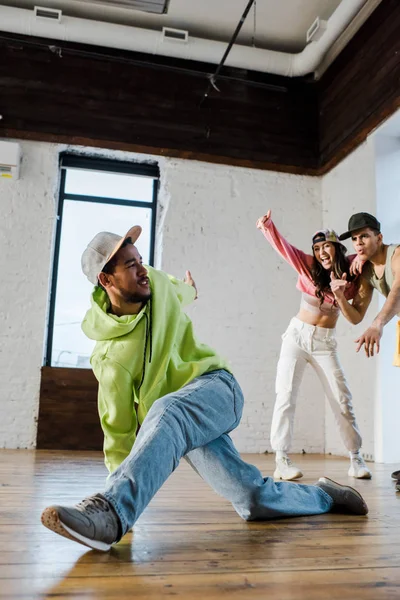 Selective focus of african american dancer breakdancing near emotional man and girl — Stock Photo