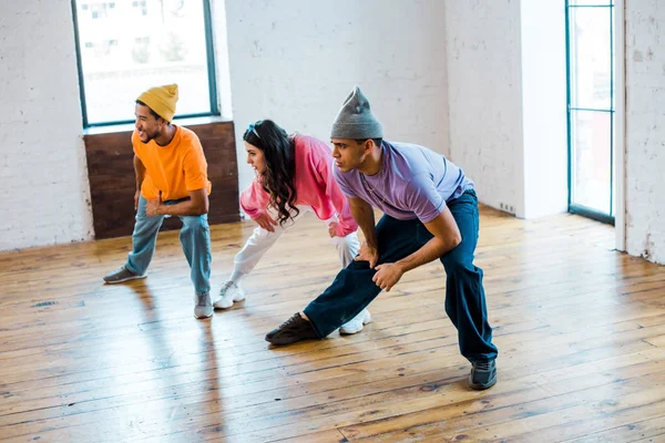 Молода жінка і стильні мультикультурні чоловіки в танцювальній студії — стокове фото