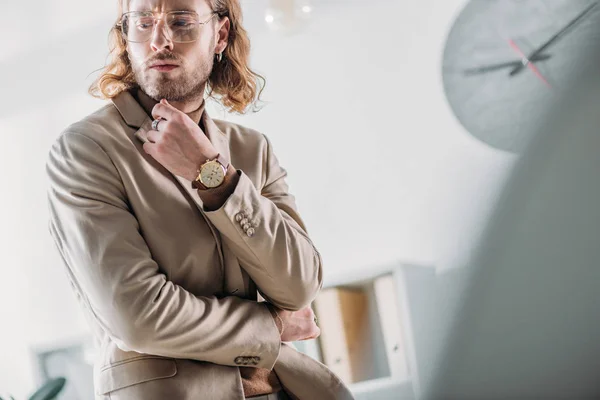 Foco seletivo de homem de negócios na moda elegante pensativo que olha longe no escritório — Fotografia de Stock
