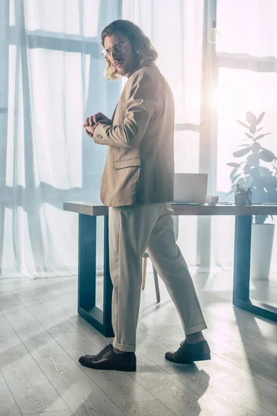 Elegante modische Geschäftsmann posiert im Sonnenlicht im Büro — Stockfoto
