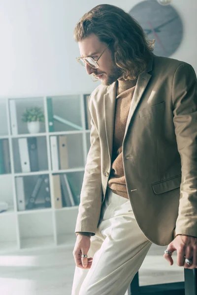Элегантный модный бизнесмен позирует в солнечном свете в офисе — стоковое фото