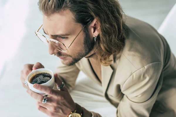 Vista aérea de elegante homem de negócios elegante segurando xícara de café no escritório — Fotografia de Stock