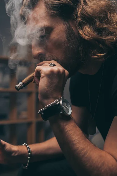 Fashionable businessman in black outfit smoking cigar — Stock Photo