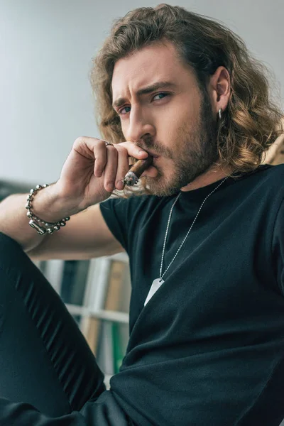 Модний випадковий бізнесмен в загальному чорному вбранні куріння сигари в офісі — стокове фото