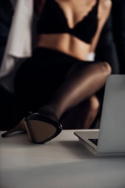 Vista recortada de chica atractiva en medias y zapato de tacón alto posando delante de la cámara web - foto de stock