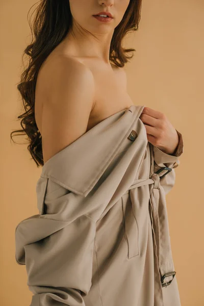Vista cortada de bela jovem mulher em casaco isolado no beide — Fotografia de Stock