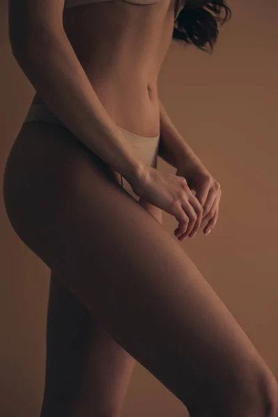 Vista recortada hermosa mujer en bragas aisladas en beige - foto de stock