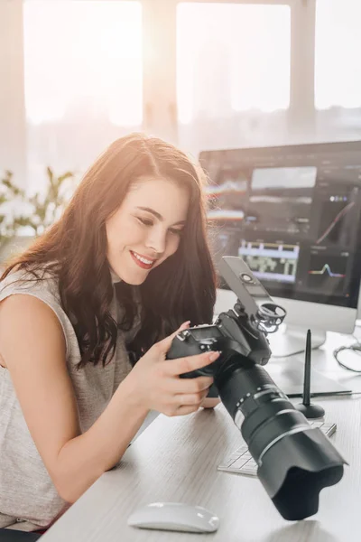 Glücklicher Kunstredakteur hält Digitalkamera in der Nähe des Computermonitors — Stockfoto