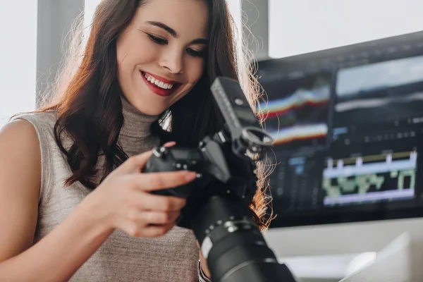 Selective focus of happy art editor holding digital camera — Stock Photo