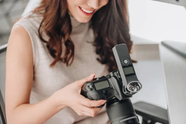 Cropped view of happy art editor holding digital camera — Stock Photo