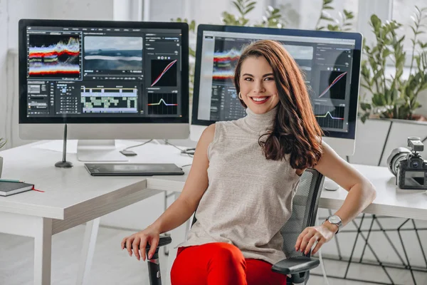 Cheerful and attractive art editor near computer monitors — Stock Photo