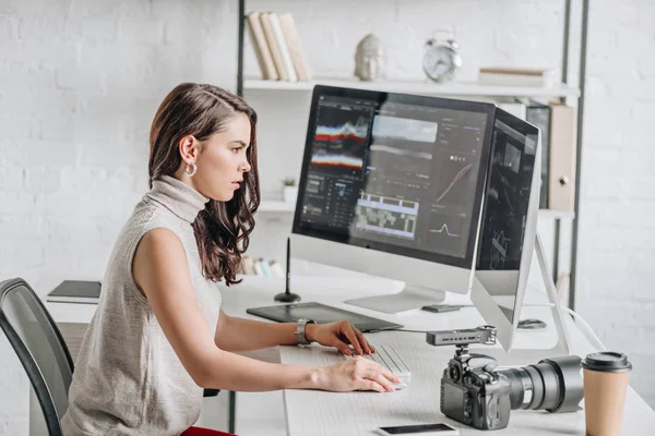 Side view of attractive art editor working near computer monitors — Stock Photo