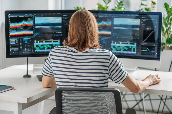 Visão traseira do editor trabalhando perto de monitores de computador — Fotografia de Stock