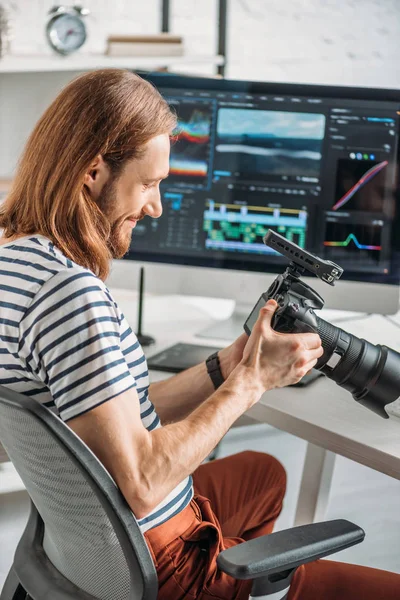 Fröhlicher bärtiger Redakteur mit Digitalkamera — Stockfoto