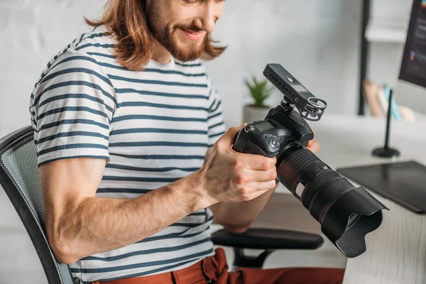 Cropped view of happy editor holding digital camera — Stock Photo