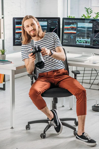 Happy and bearded art editor holding digital camera — Stock Photo