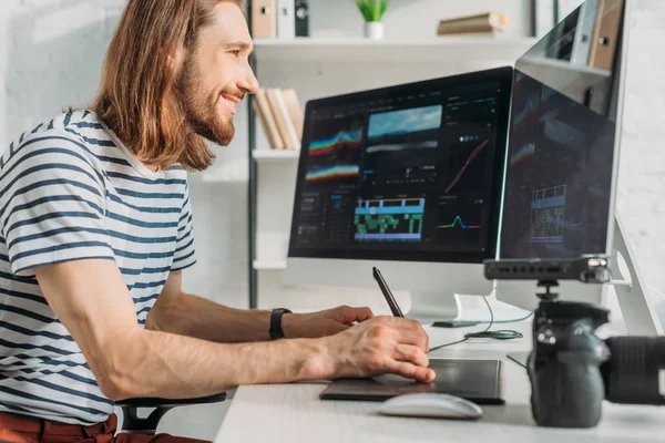 Seitenansicht eines glücklichen Filmemachers, der im Studio arbeitet — Stockfoto