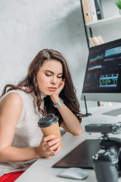 Недовольный редактор смотрит на бумажную чашку — Stock Photo