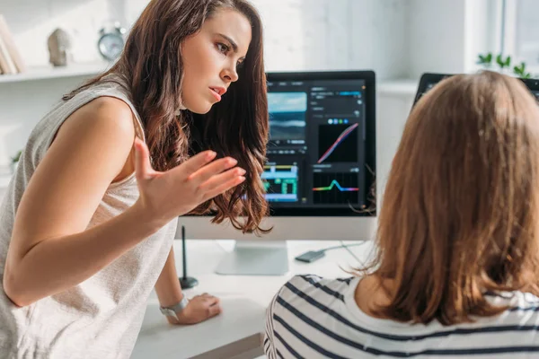 Selective focus of displeased editor looking at coworker — Stock Photo