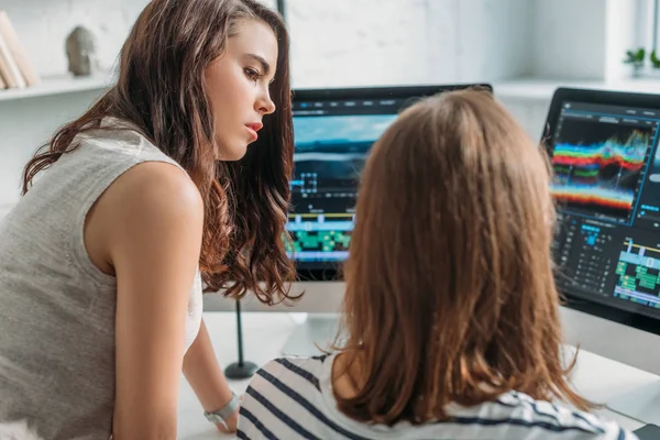 Selective focus of attractive editor looking at coworker — Stock Photo