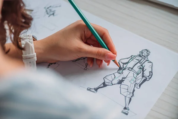 Селективный фокус иллюстратора, рисующего мультяшного персонажа на бумаге — стоковое фото