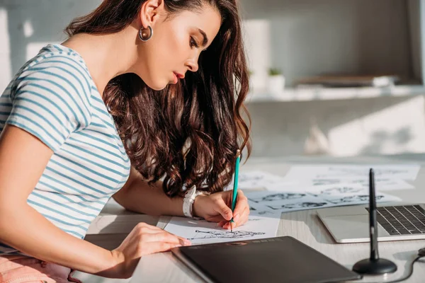 Side view of illustrator drawing cartoon character on paper — Stock Photo